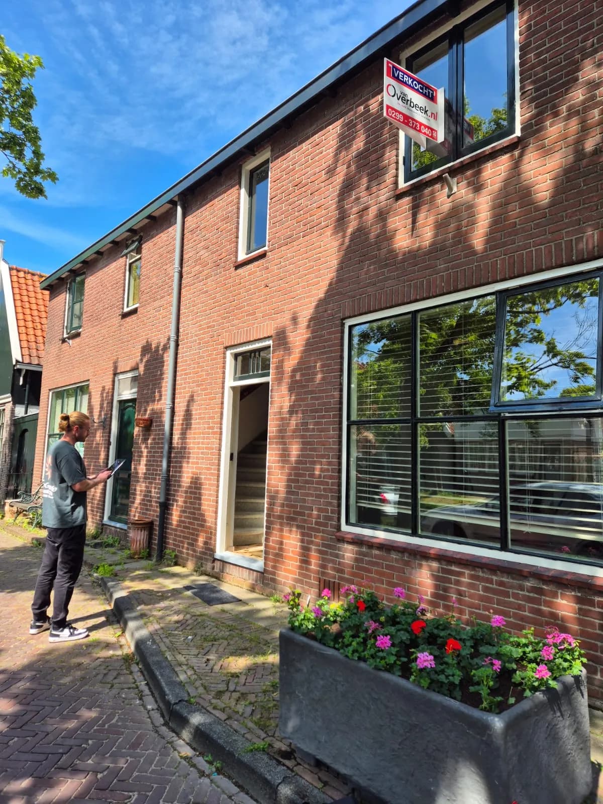 Adviseur van Let’s GO Labels neemt de gevel van een verkochte woning op met een tablet
