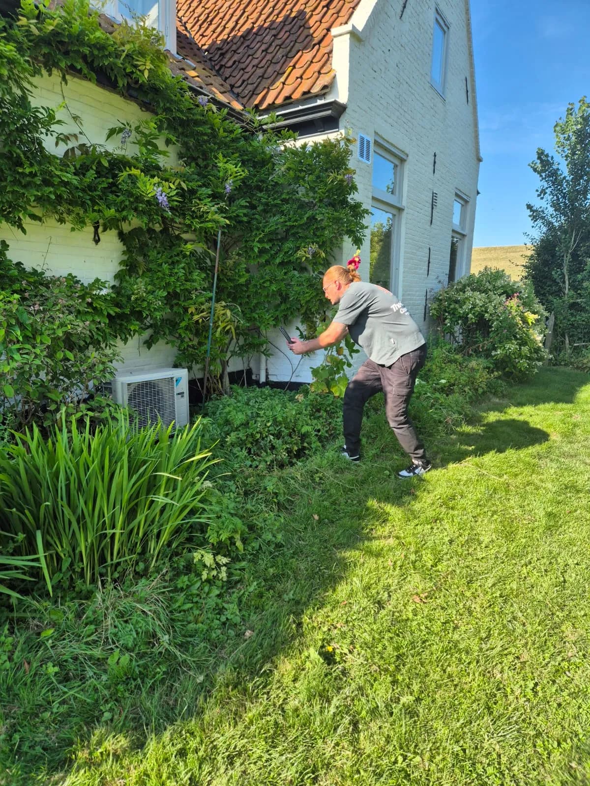 Buitenunit van een warmtepomp wordt vastgelegd tijdens een opname op locatie